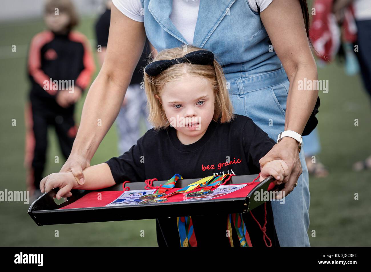 A girl from Poland holds a tray with medals during the Polish National