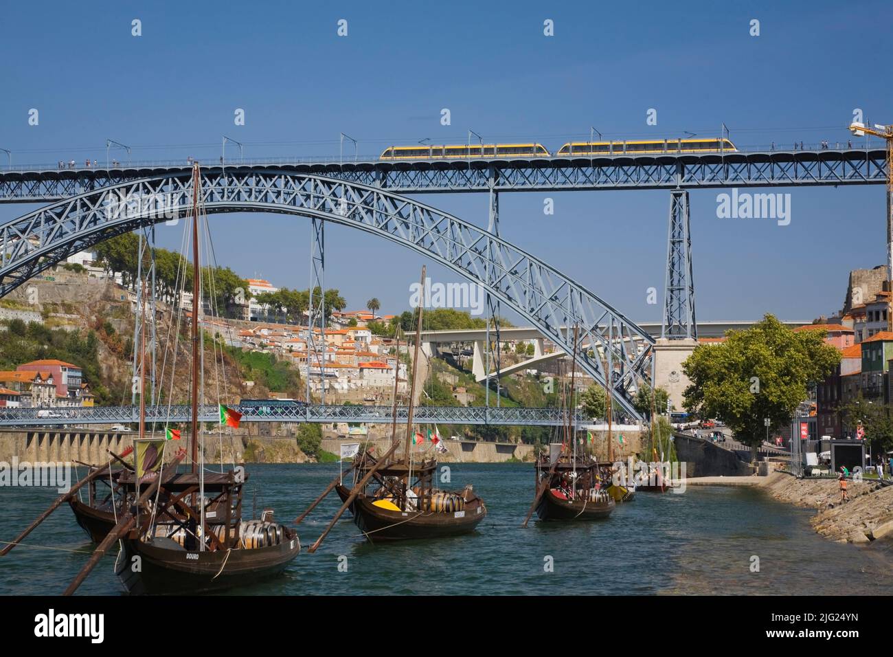 Dom Luis I bridge over the Douro river with moored traditional port wine boats, Porto, Portugal, Europe. Stock Photo