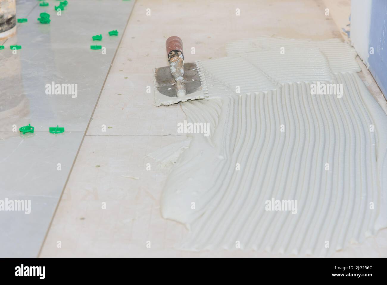 Installing adhesive on a bathroom floor with wet mortar ensures that