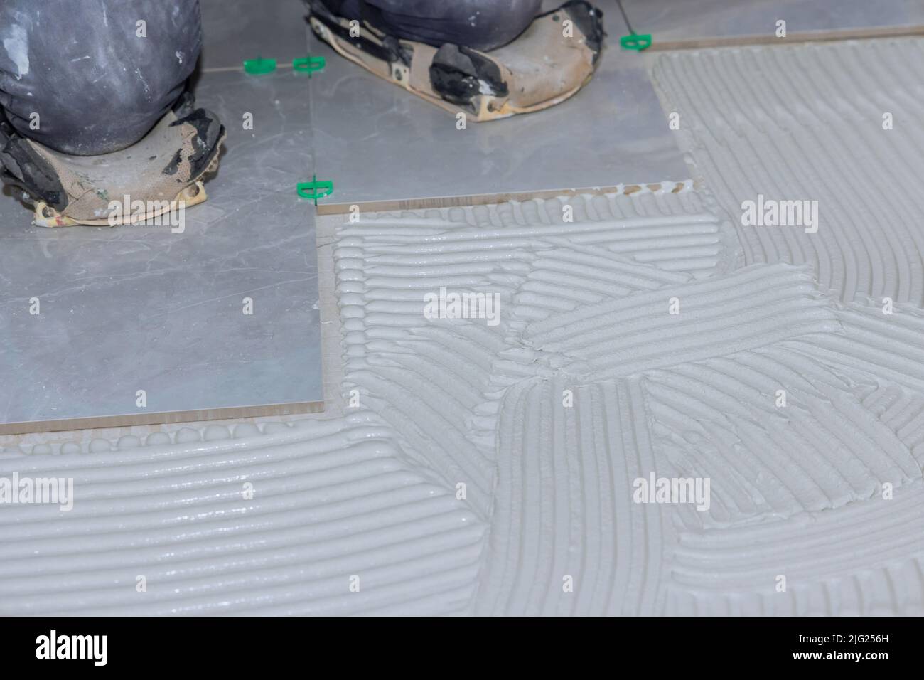 Troweling mortar puts adhesive on a concrete floor in preparation for