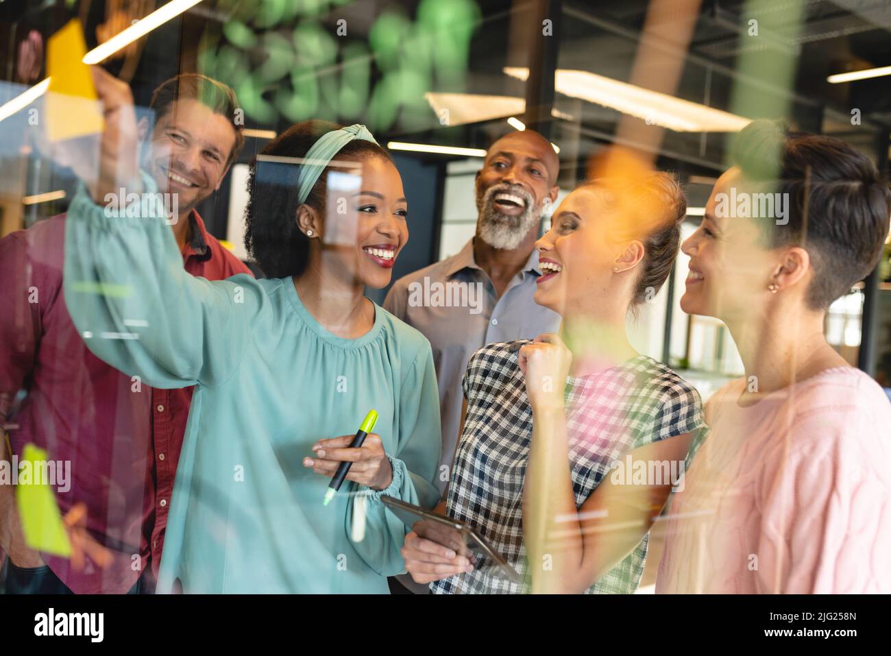 Happy multiracial male and female colleagues in meeting at creative ...