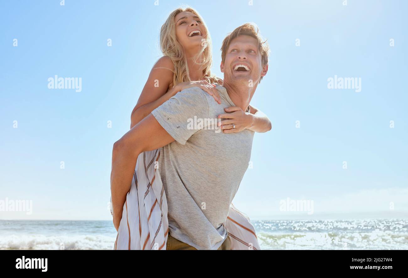 A young loving couple having fun with a piggyback ride, enjoying a day ...