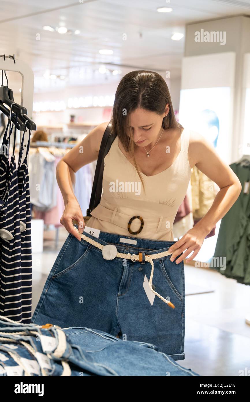 Young female customer trying on shorts Stock Photo