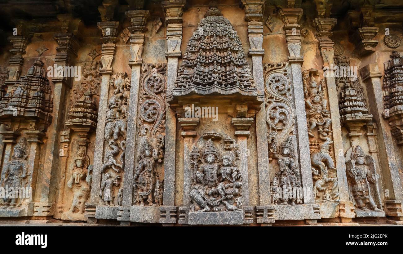 Sculpture of Lord Shiva with Parvati under an aedicule flanked by other deities, Bucesvara temple of Koravangala, Hassan, Karnataka, India. Stock Photo