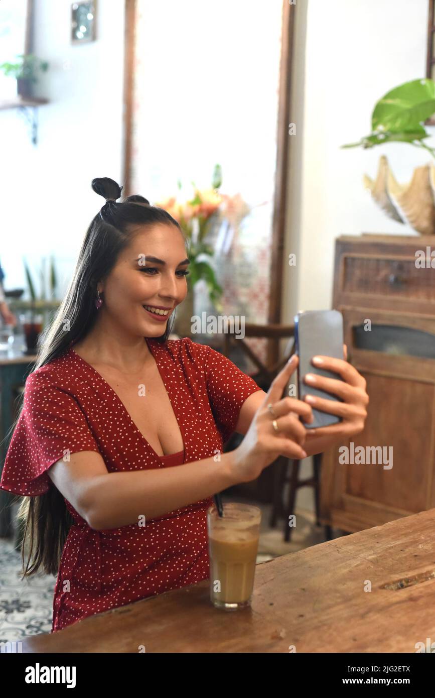 Young woman taking selfie in a coffee shop Stock Photo