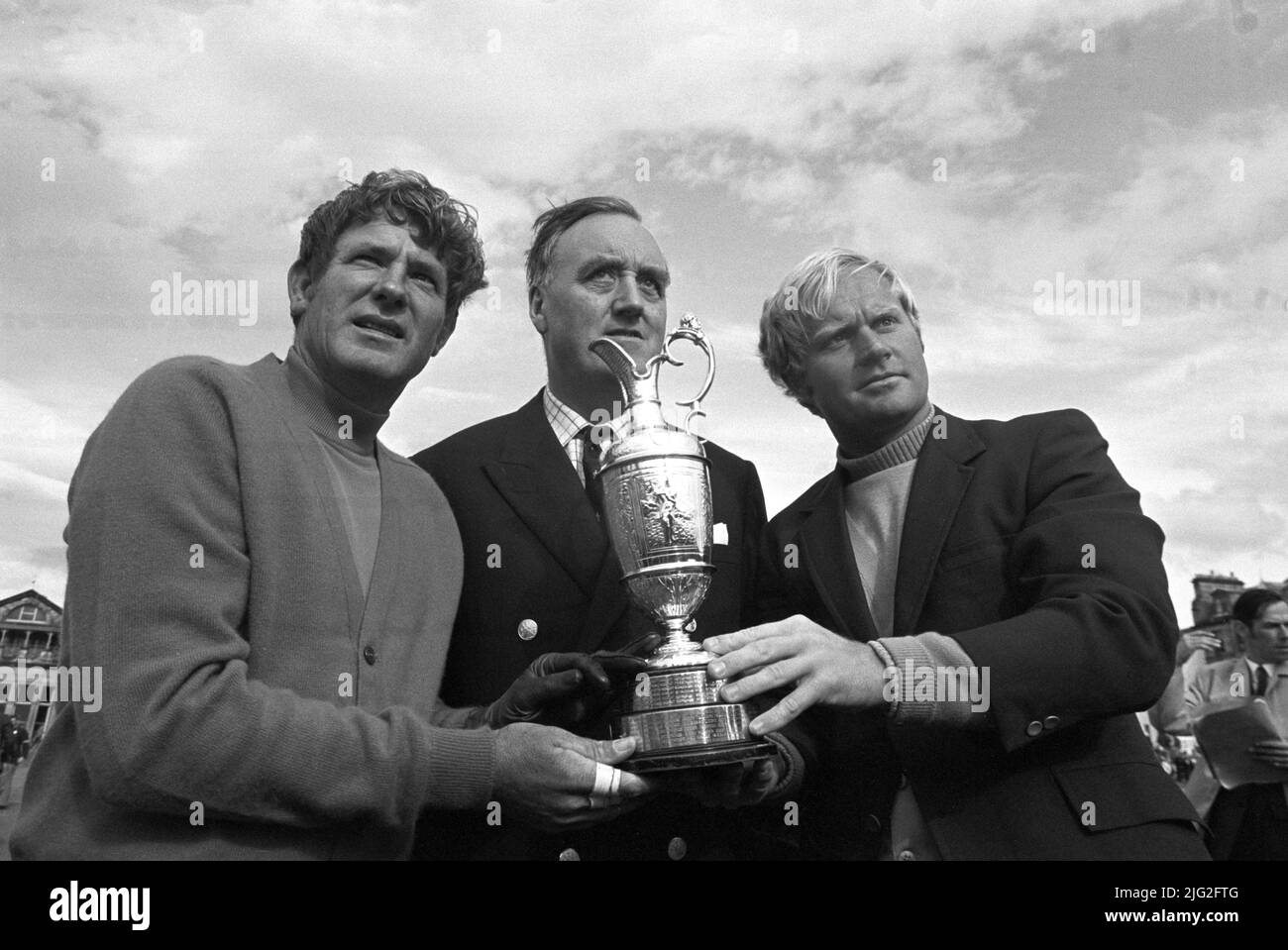 File photo dated 11-07-1970 of America's Doug Sanders (left) and Jack Nicklaus (right) with the Open Golf trophy they are sharing for a few hours. Between them is Cabinet Minister Mr William Whitelaw, captain of the Royal and Ancient Golf Club. The winner will be decided tomorrow when Sanders and Nicklaus play off over 18 holes. After saving par from the Road Hole bunker in the final round, Sanders needed to par the 18th to finish a shot ahead of Jack Nicklaus and left himself with a short putt for the title. Standing over the ball, Sanders thought he saw a small pebble on his line and stooped Stock Photo