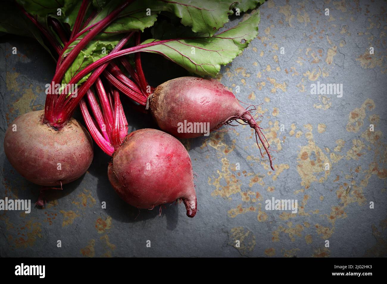 Fresh beetroot with leaves on a grey stone background. Healthy food. Top view. Free space for your text Stock Photo