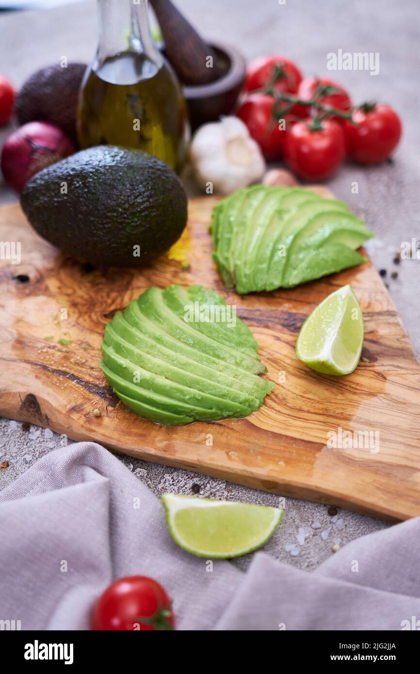 Sliced avocado on wooden cutting board at domestic kitchen Stock Photo ...