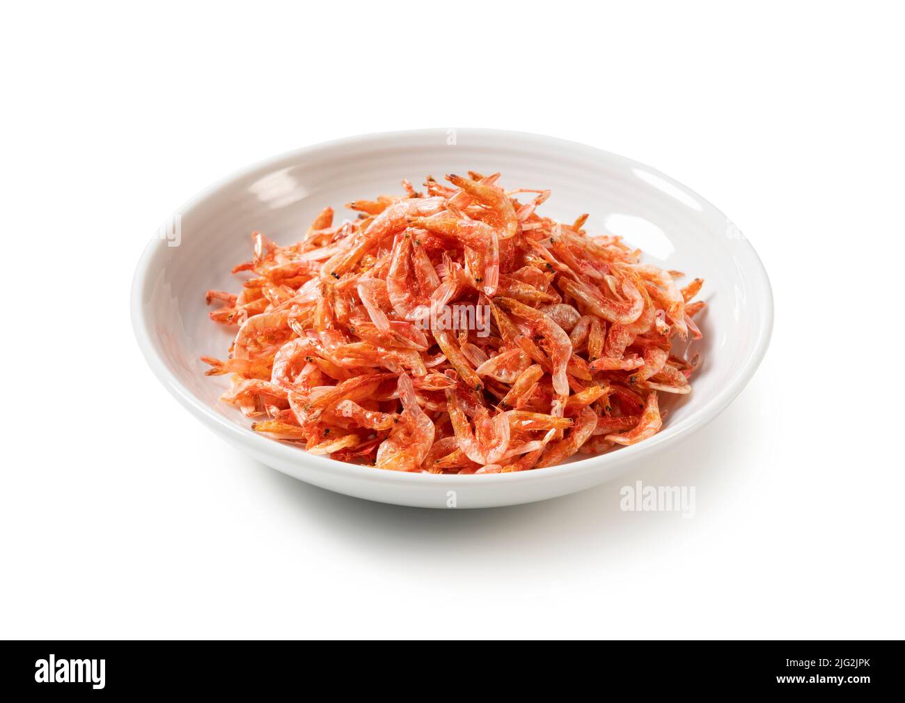 Dried sakura shrimps on a plate placed on a white background. Image of