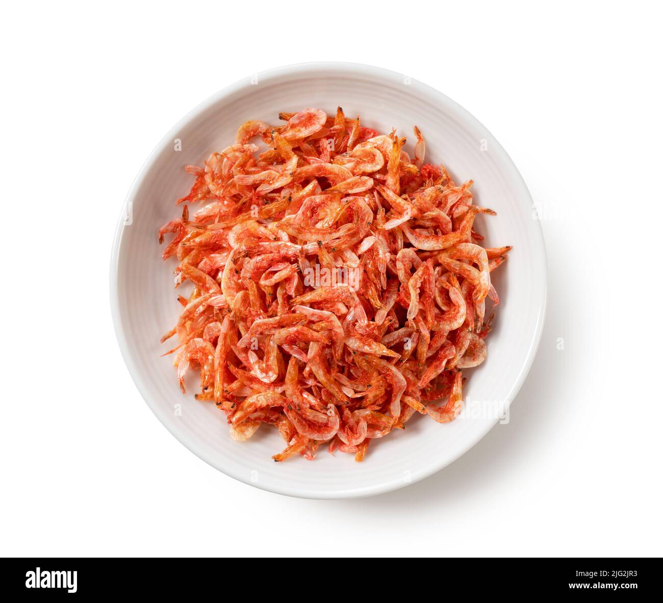 Dried sakura shrimps on a plate placed on a white background. Image of
