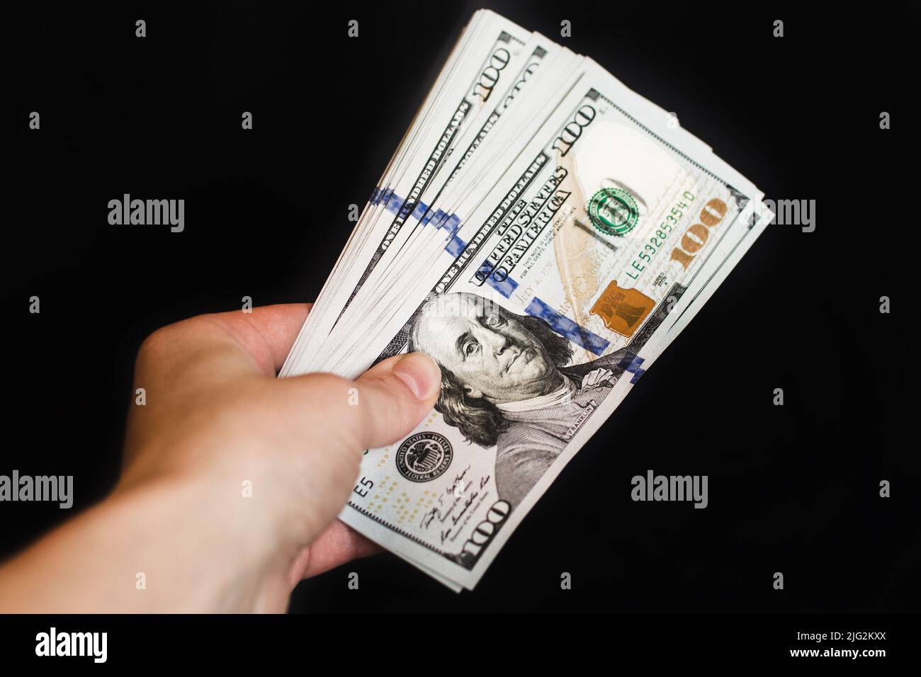 Hand with dollar bills on a black background. Stock Photo