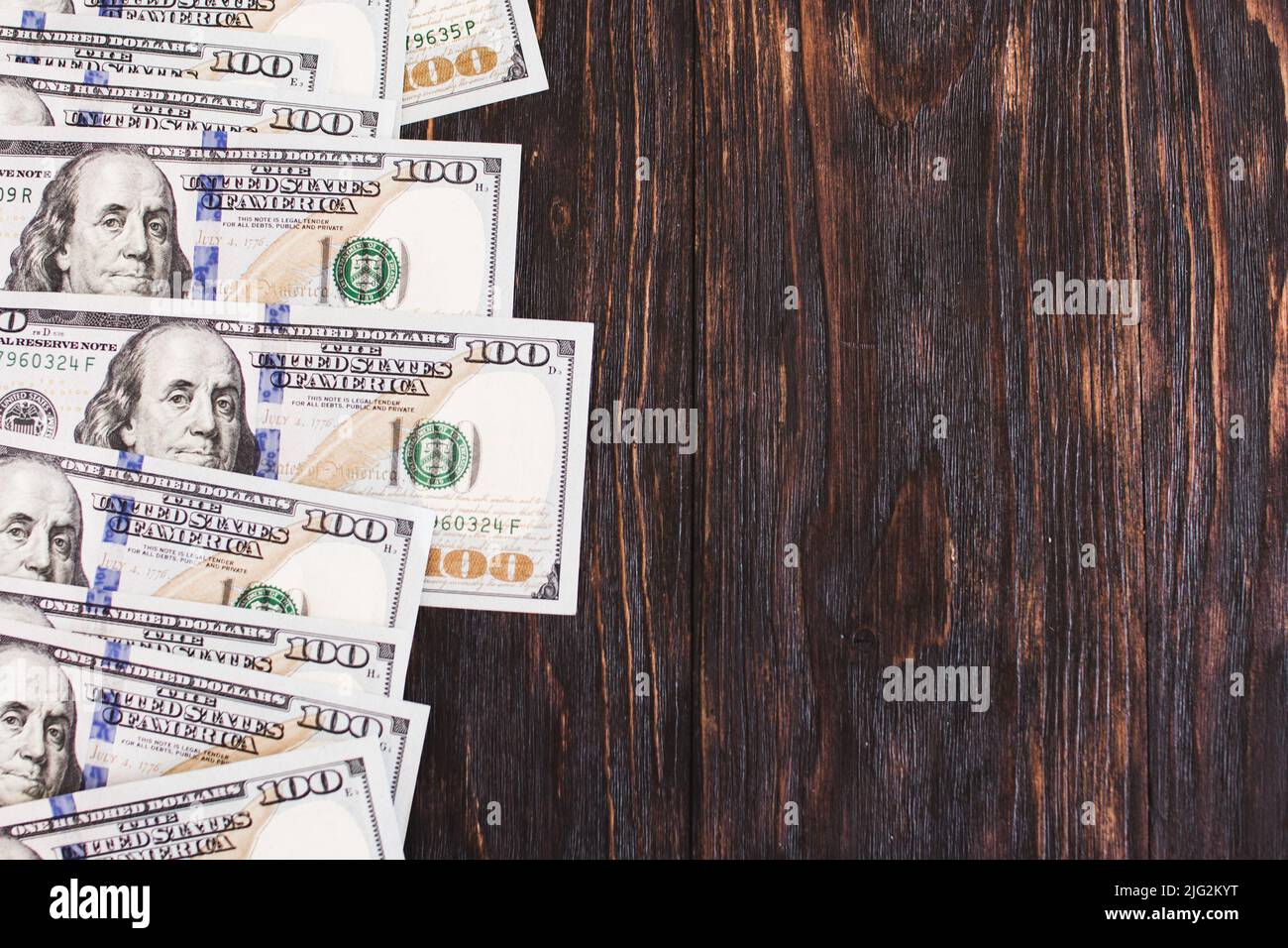 Hundred dollar bills on a wooden background. Blank space. Stock Photo