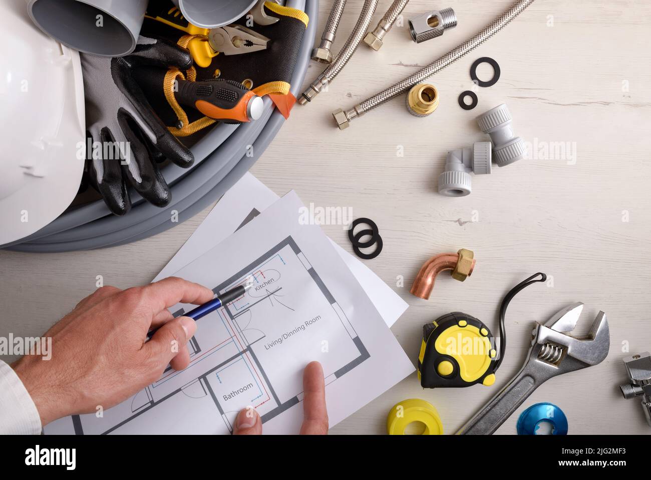 Engineer showing scheme of water installation on table with tools and ...