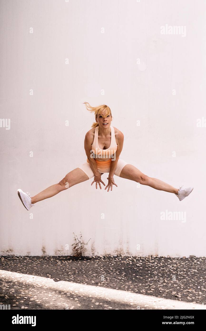 Isolated female athlete jumping outdoors Stock Photo