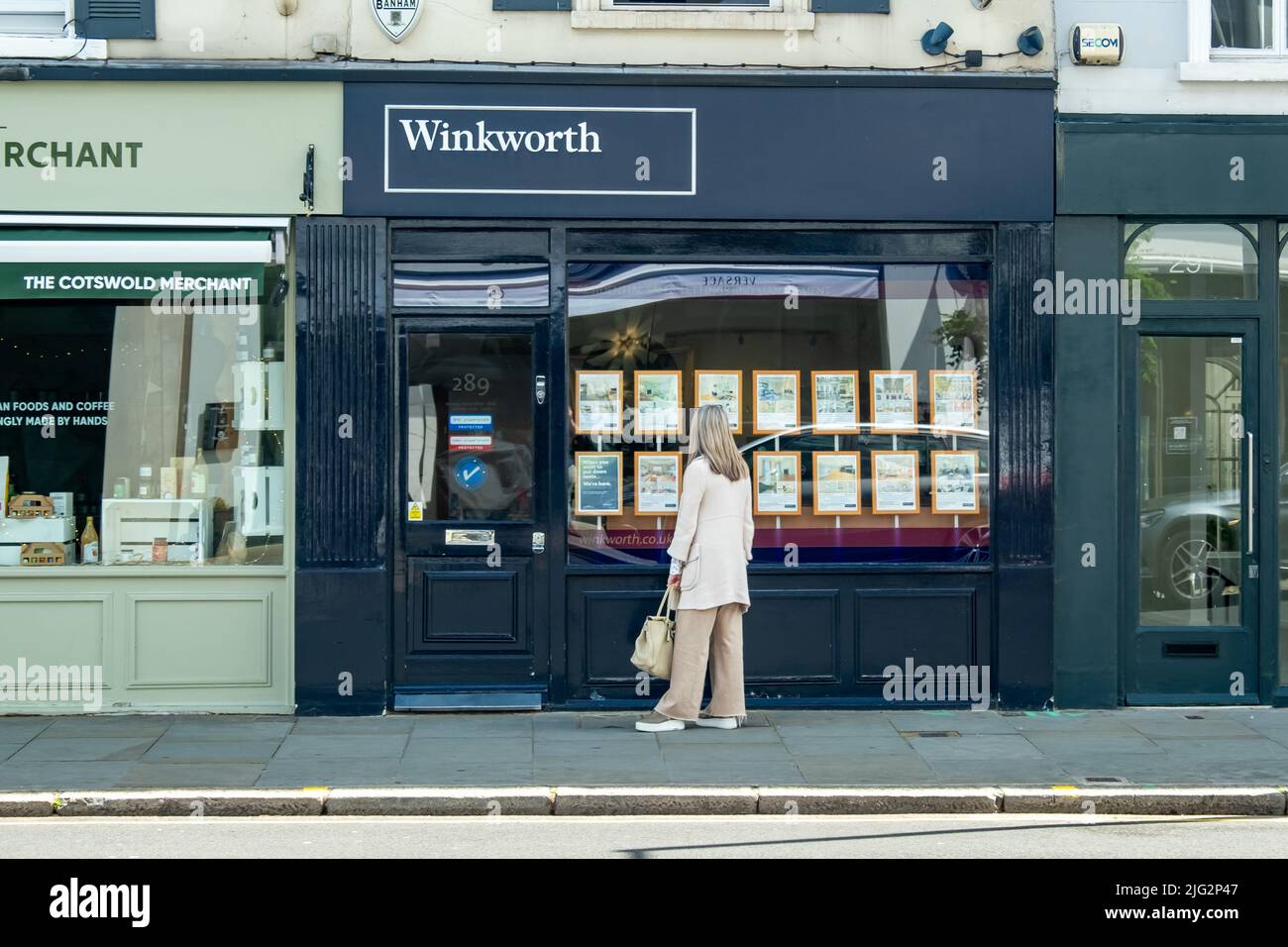 London- June 2022: Person looking at properties being advertised in estate agent shop window Stock Photo