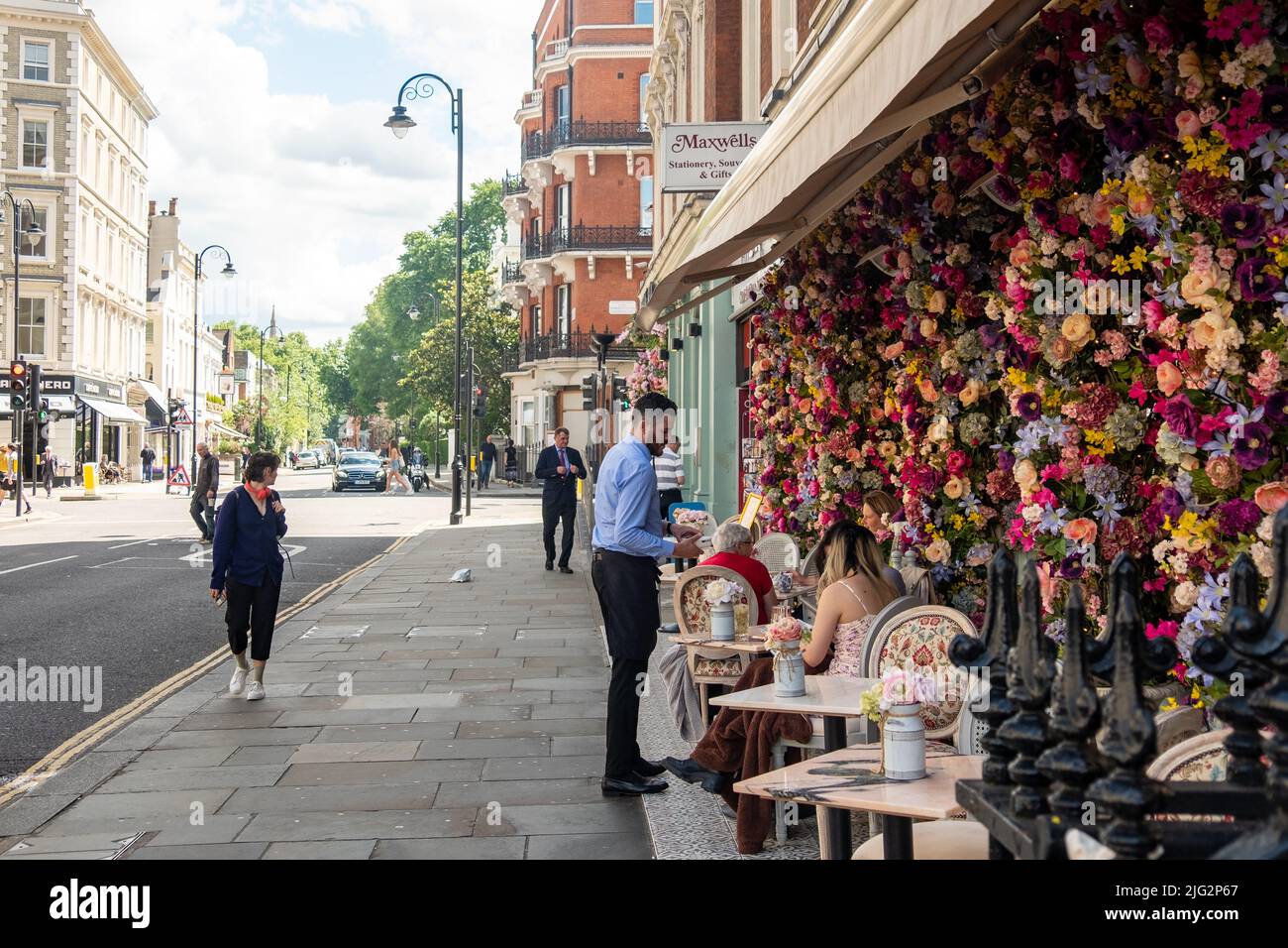 London- June 2022: Waiter and outdoor seating at restaurant on Gloucester Road, Kensington and Chelsea Stock Photo