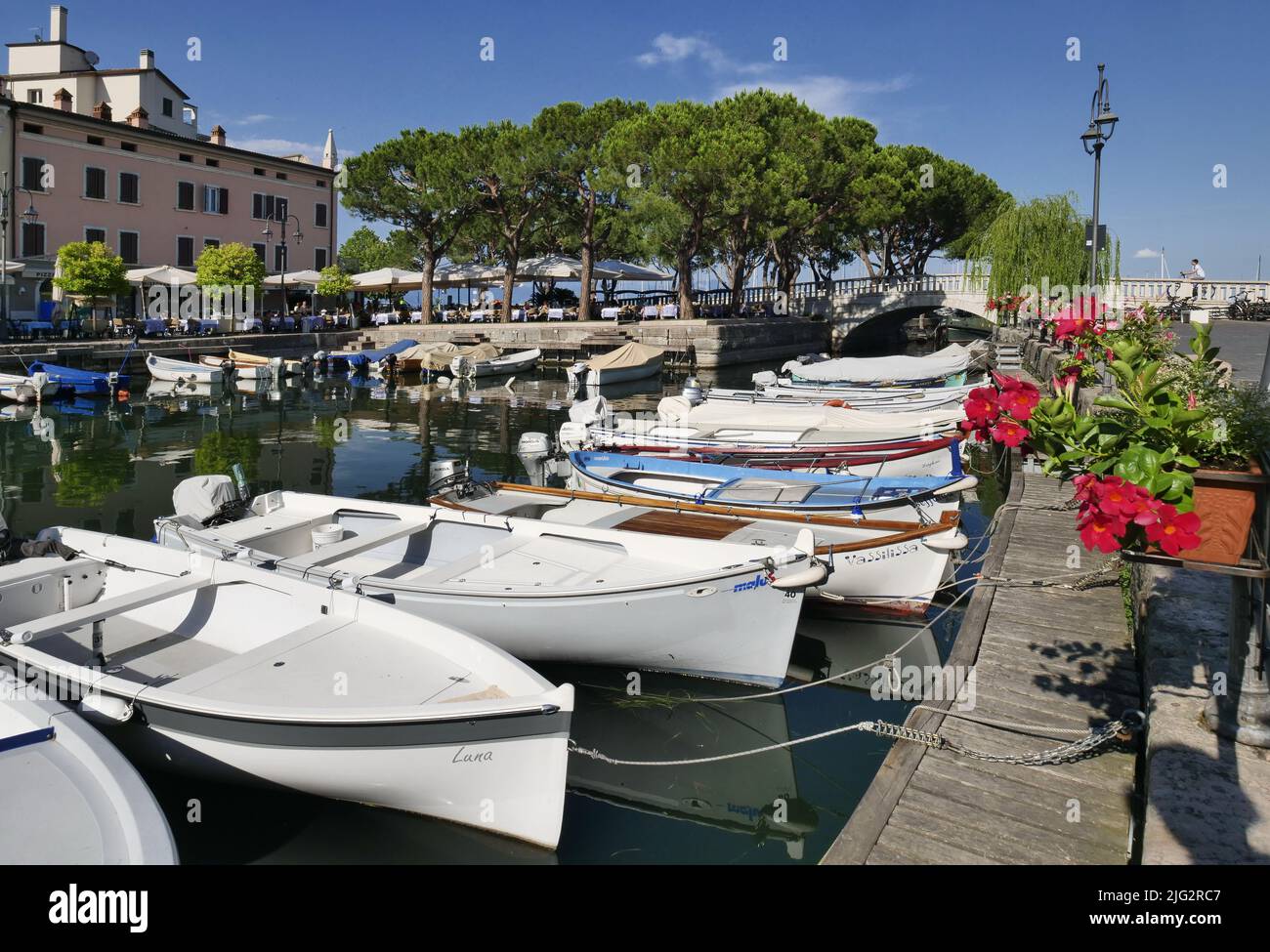 Old harbour full of boats in Desenzano del Garda. Brescia, Lombardy, Italy. City Centre of Desenzano on Lake Garda. Stock Photo