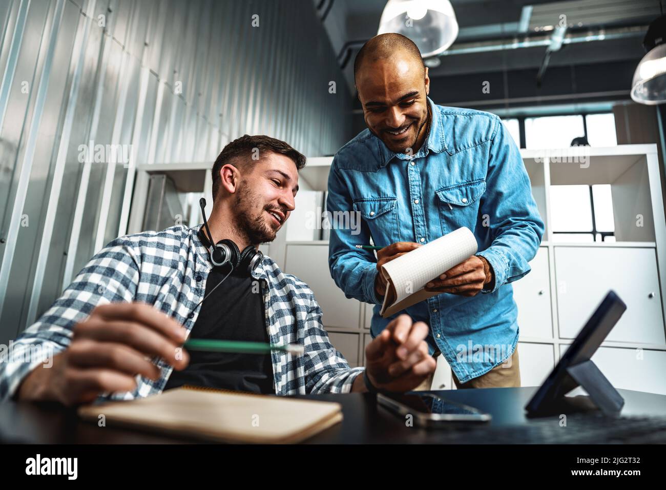 Two young men working together on a new business project in office ...