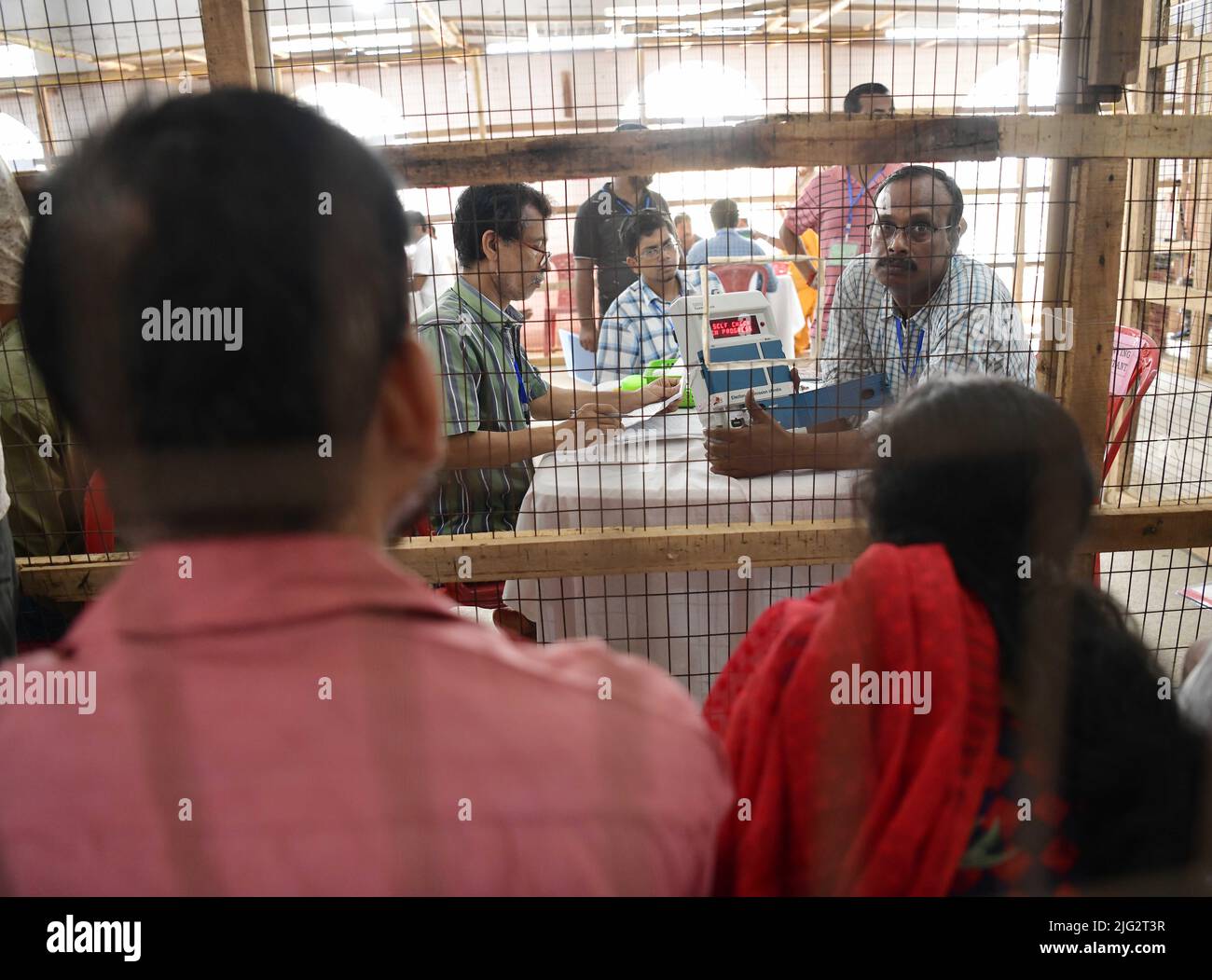 Election staff members with an electronic voting machine (EVM) during the counting of votes of the Tripura Assembly By-Election, at a counting centre in Agartala. Tripura, India. Stock Photo