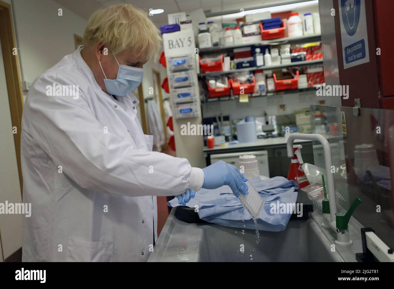 File photo dated 18/09/20 of Prime Minister Boris Johnson washing immunological assays during a visit to the Jenner Institute in Oxford, where he toured the laboratory and met scientists who are leading the COVID vaccine research. Boris Johnson will publicly announce his resignation later today, likely before lunchtime, the BBC is reporting. Issue date: Thursday July 7, 2022. Stock Photo