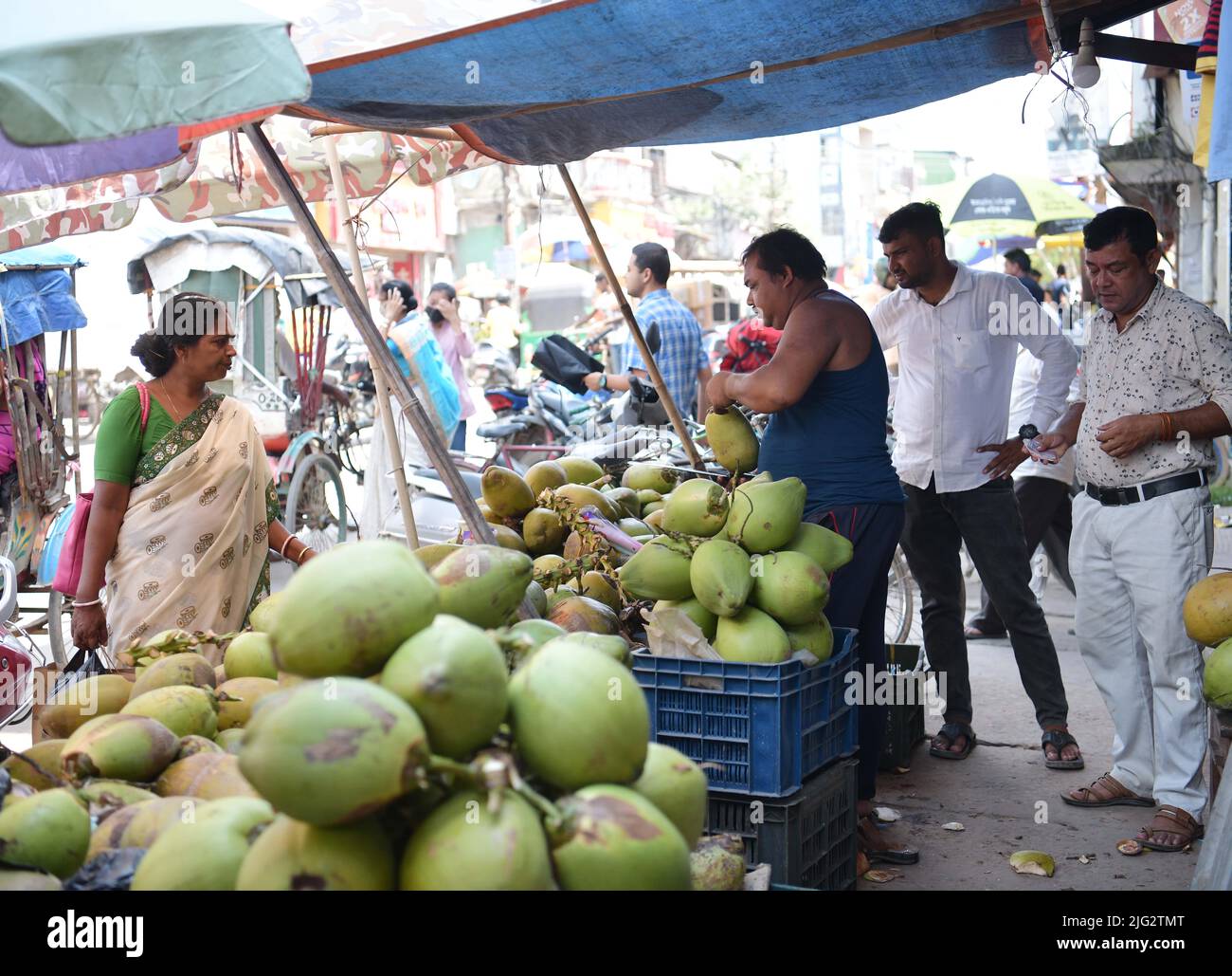 A Coconut vendor cuts coconuts and sells the coconuts to the people who