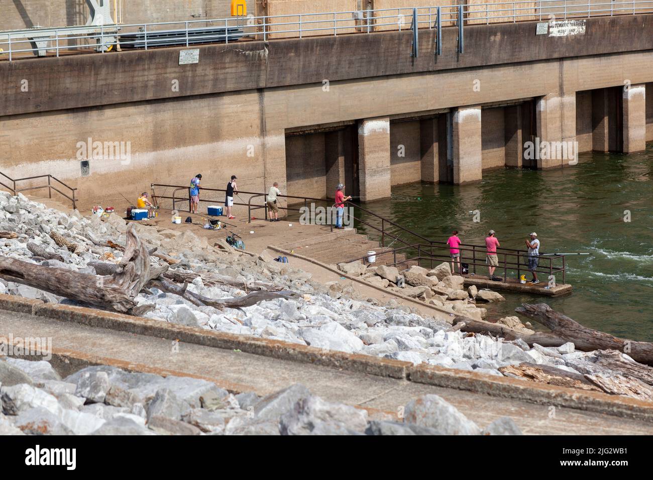 A group of people fishing at the base of Pickwick hydroelectric dam on  May 21st, 2022. In Hardin County, Tennessee. Stock Photo