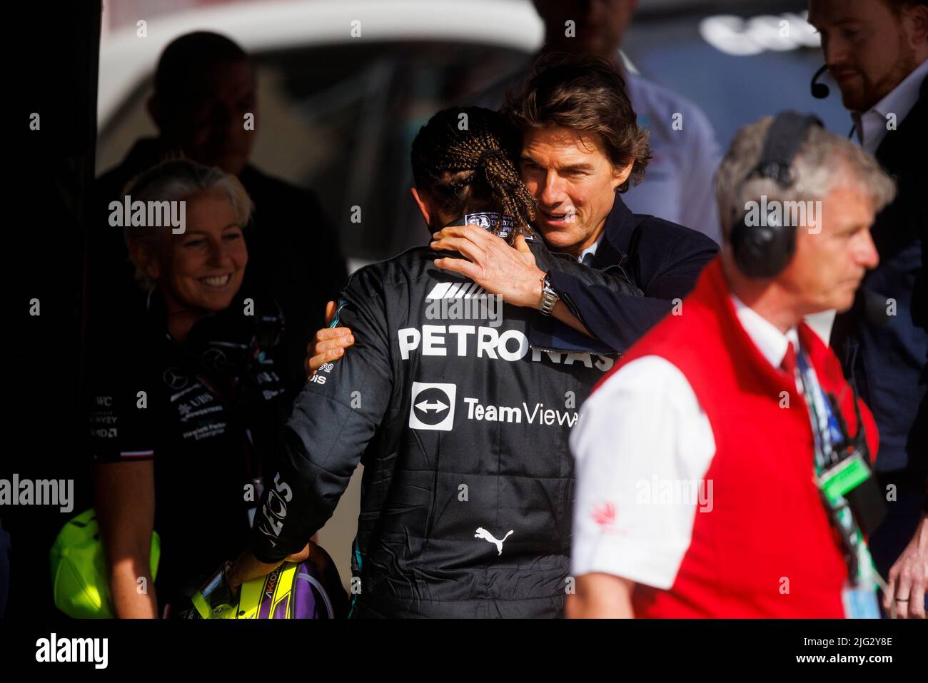 Tom Cruise hugs and consoles Lewis Hamilton underneath the podium at the F1 British Grand Prix as he finishes third whilst Carlos Sainz wins his first Stock Photo