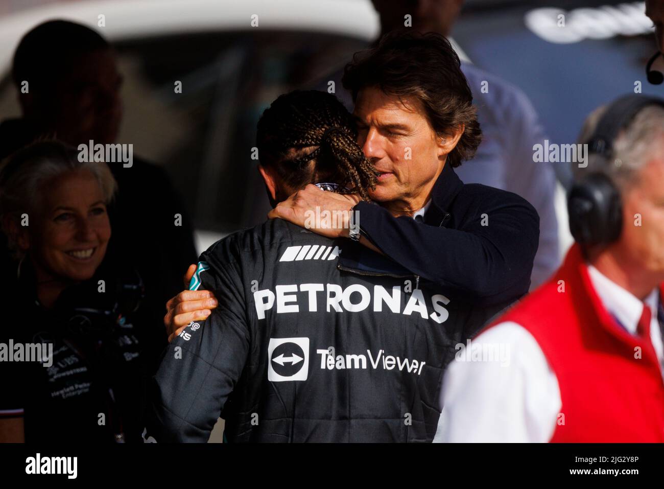Tom Cruise hugs and consoles Lewis Hamilton underneath the podium at the F1 British Grand Prix as he finishes third whilst Carlos Sainz wins his first Stock Photo