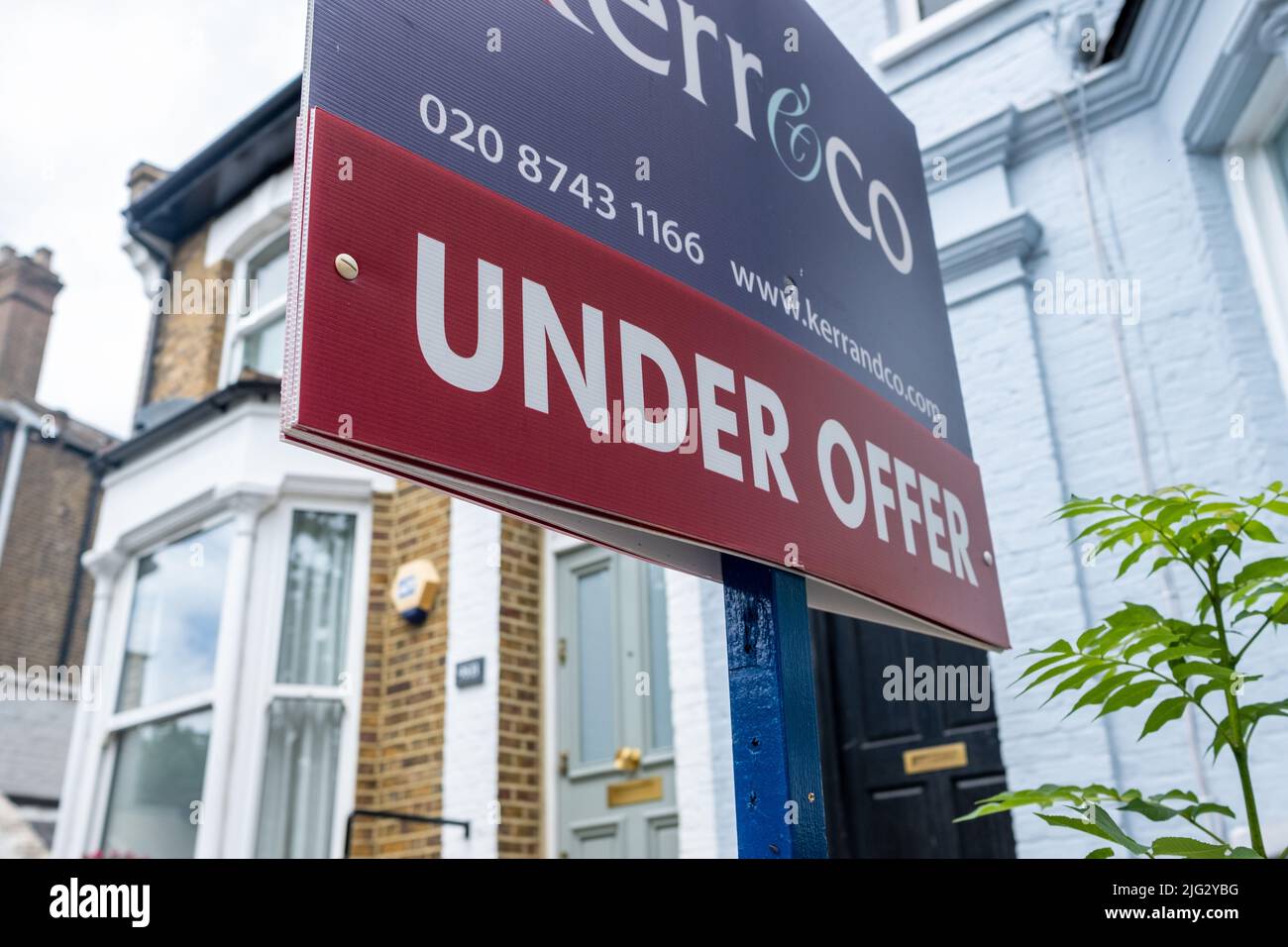 London- June 2022: Estate agent 'Under Offer' sign on street of suburban British houses Stock Photo