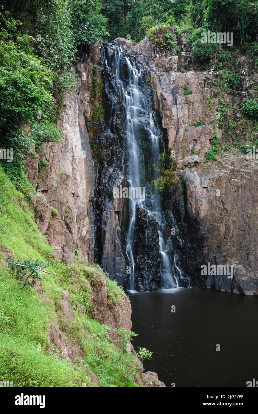Waterfall called Haew Narok covered by green trees inside tropical rainforest in Khao Yai National park of Thailand. Forest has less of water in summe Stock Photo