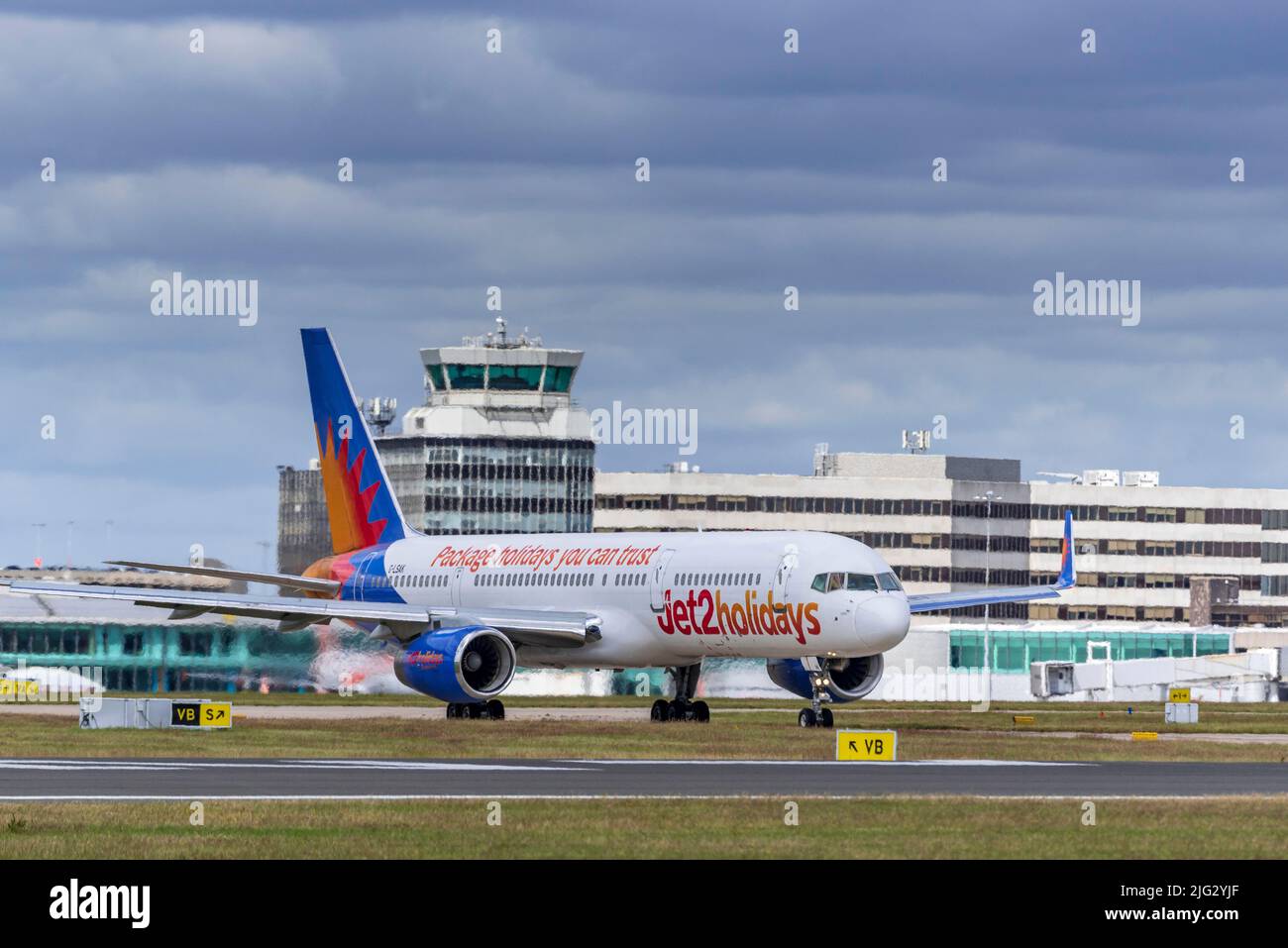 Jet2 Holidays Boeing 75723N REG GLSAK at Manchester airport with the main terminal in the