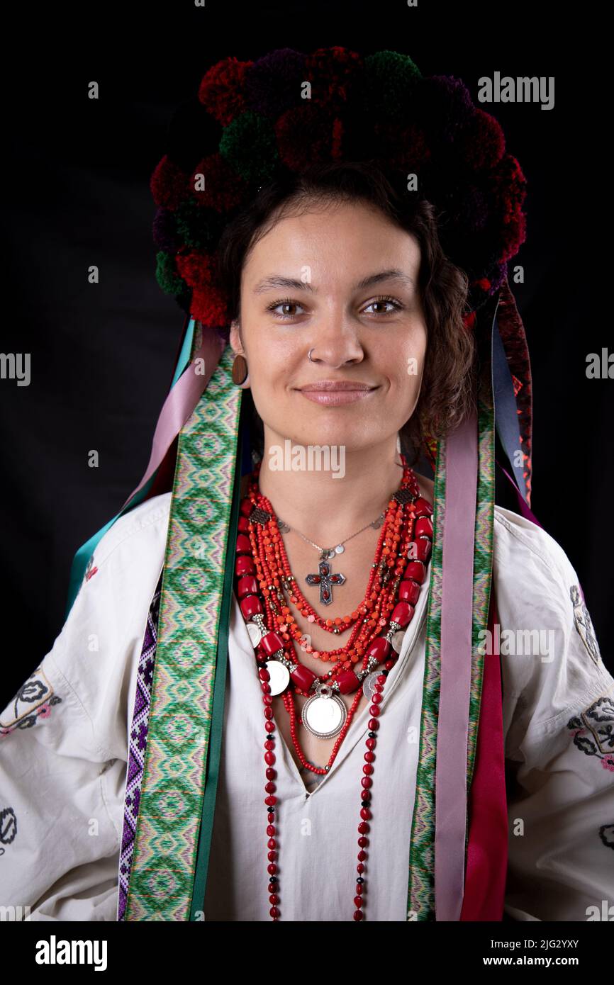 A beautiful Ukrainian woman in traditional clothes on dark background ...