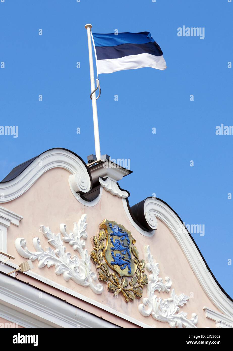 Estonia flag flying; The Estonian flag flying from the roof of the parliament building against a blue sky in Tallinn, Estonia Europe Stock Photo