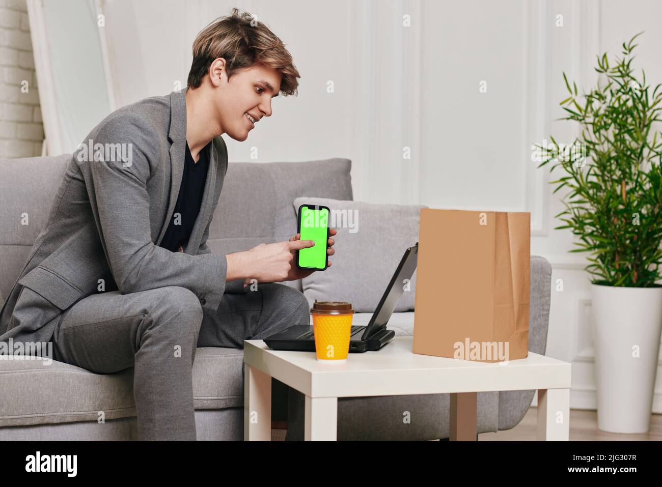Handsome caucasian young man using phone at home Stock Photo