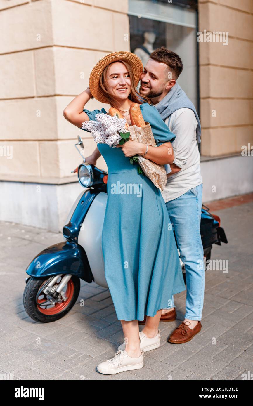 Happy beautiful couple on scooter in european city Stock Photo