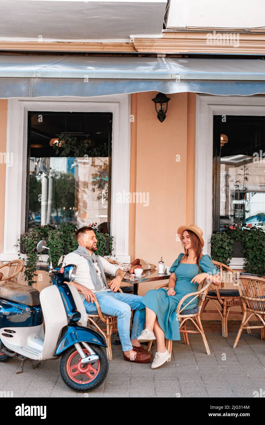 Couple dating drinking coffee at sidewalk cafe outdoors on date in summer sunny day Stock Photo