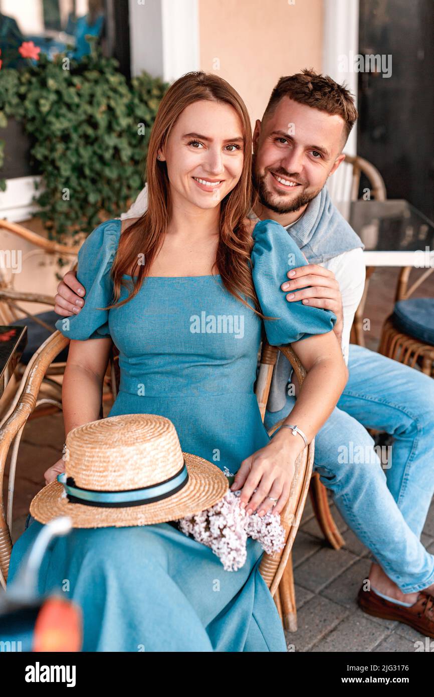 Beautiful loving couple sitting in outdoor cafe and smiling at camera Stock Photo