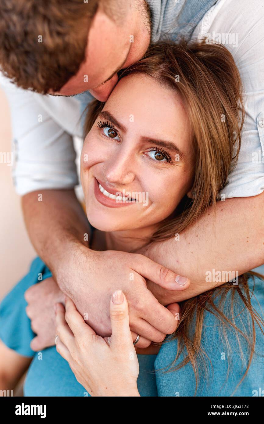 Beautiful couple of young brunette lovers are hugging with love and tenderness on city cafe Stock Photo