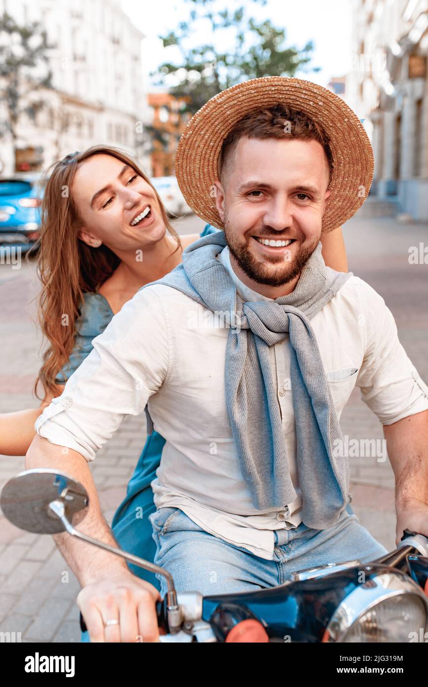 Couple having fun riding scooter in old European city Stock Photo