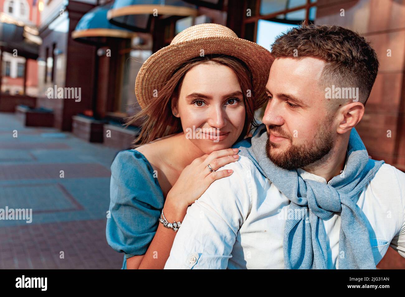 young couple riding a vintage scooter in the street in sunny summer day Stock Photo