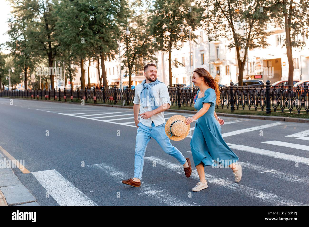 Romantic couple spending time together in the city while walking on a crosswalk. Stock Photo
