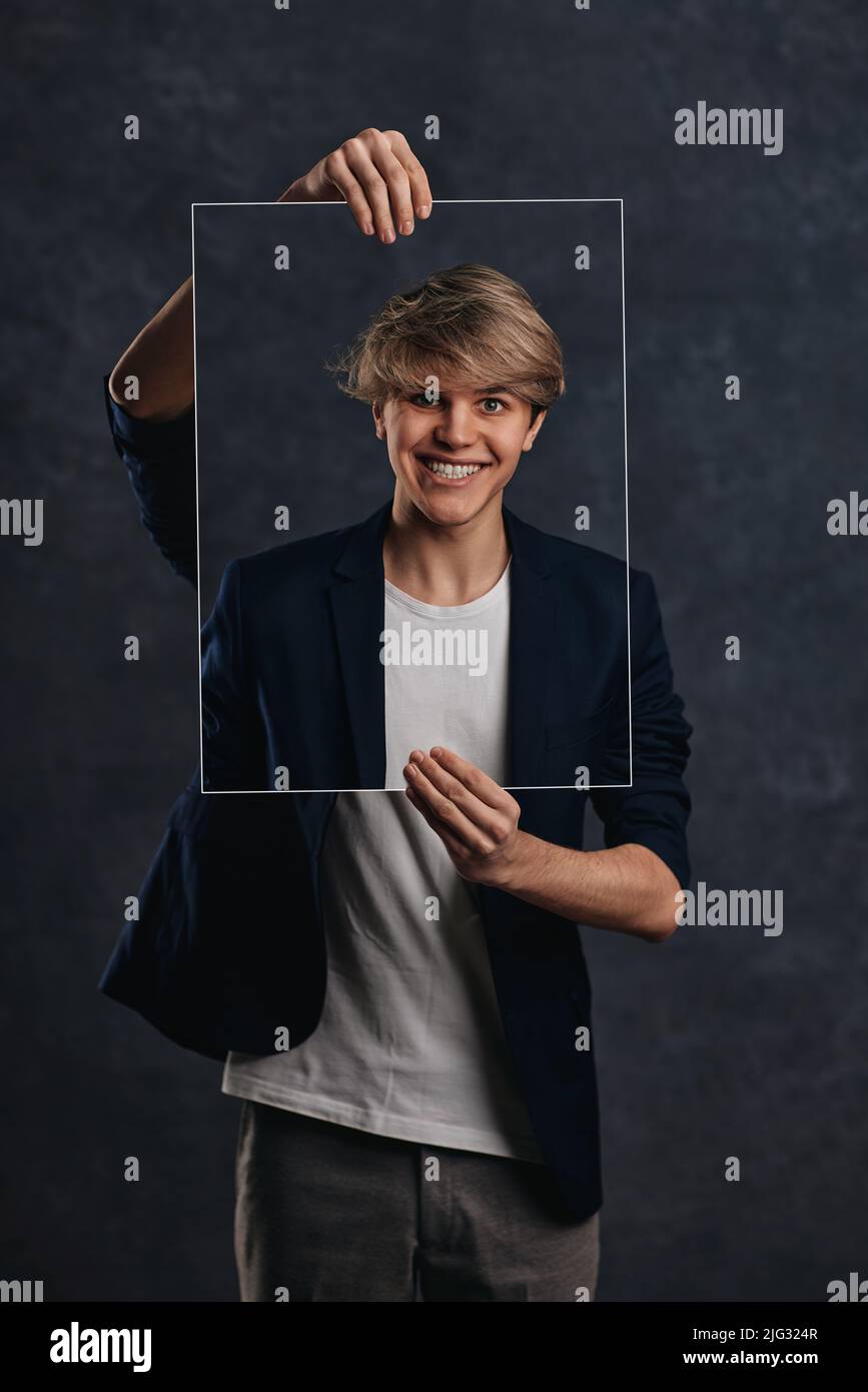 young man holding face portraits with different emotions Stock Photo ...