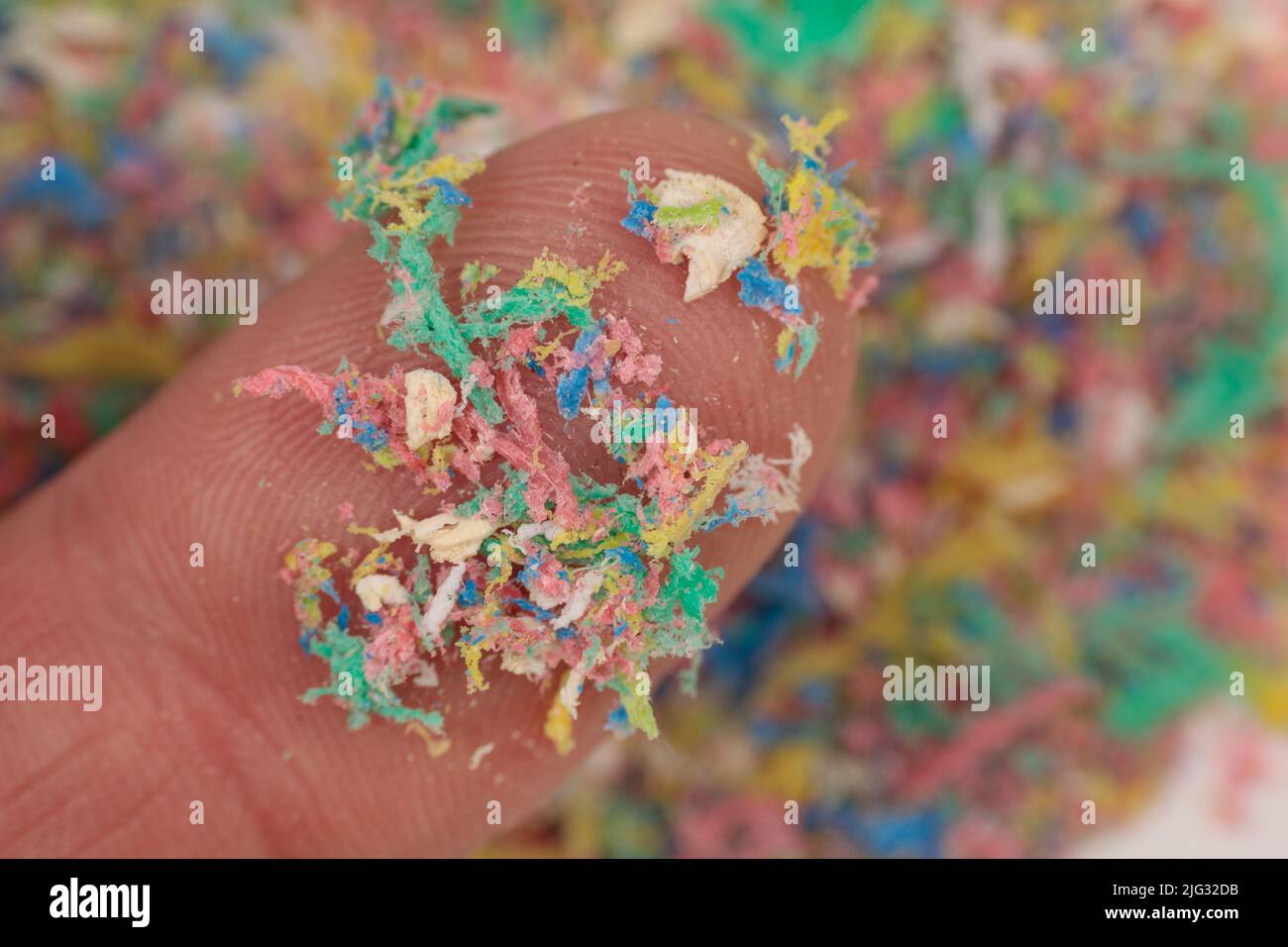 Small plastic pellets on the finger. Closeup of micro plastic as