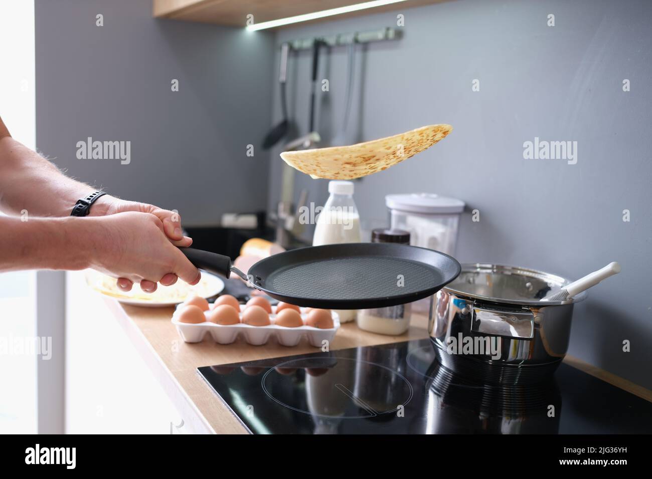 https://c8.alamy.com/comp/2JG36YH/person-deftly-flips-the-pancakes-in-pan-2JG36YH.jpg