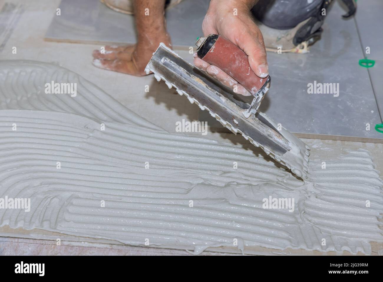 To apply adhesive to the bathroom floor, spread wet mortar before