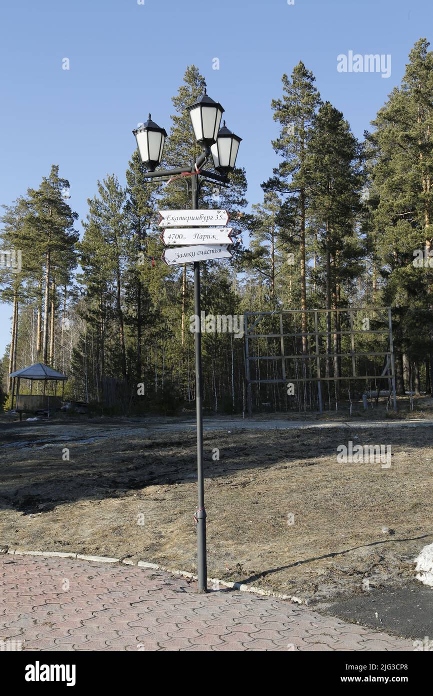 Light pole with signs at the monument on the border between Europe & Asia near Ekaterinburg, Russia, indicating the distances to several major cities Stock Photo
