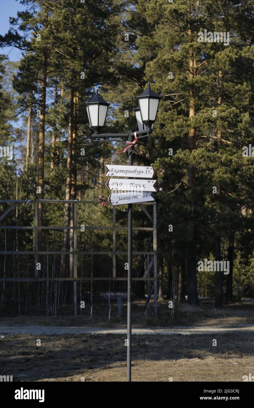 Light pole with signs at the monument on the border between Europe & Asia near Ekaterinburg, Russia, indicating the distances to several major cities Stock Photo