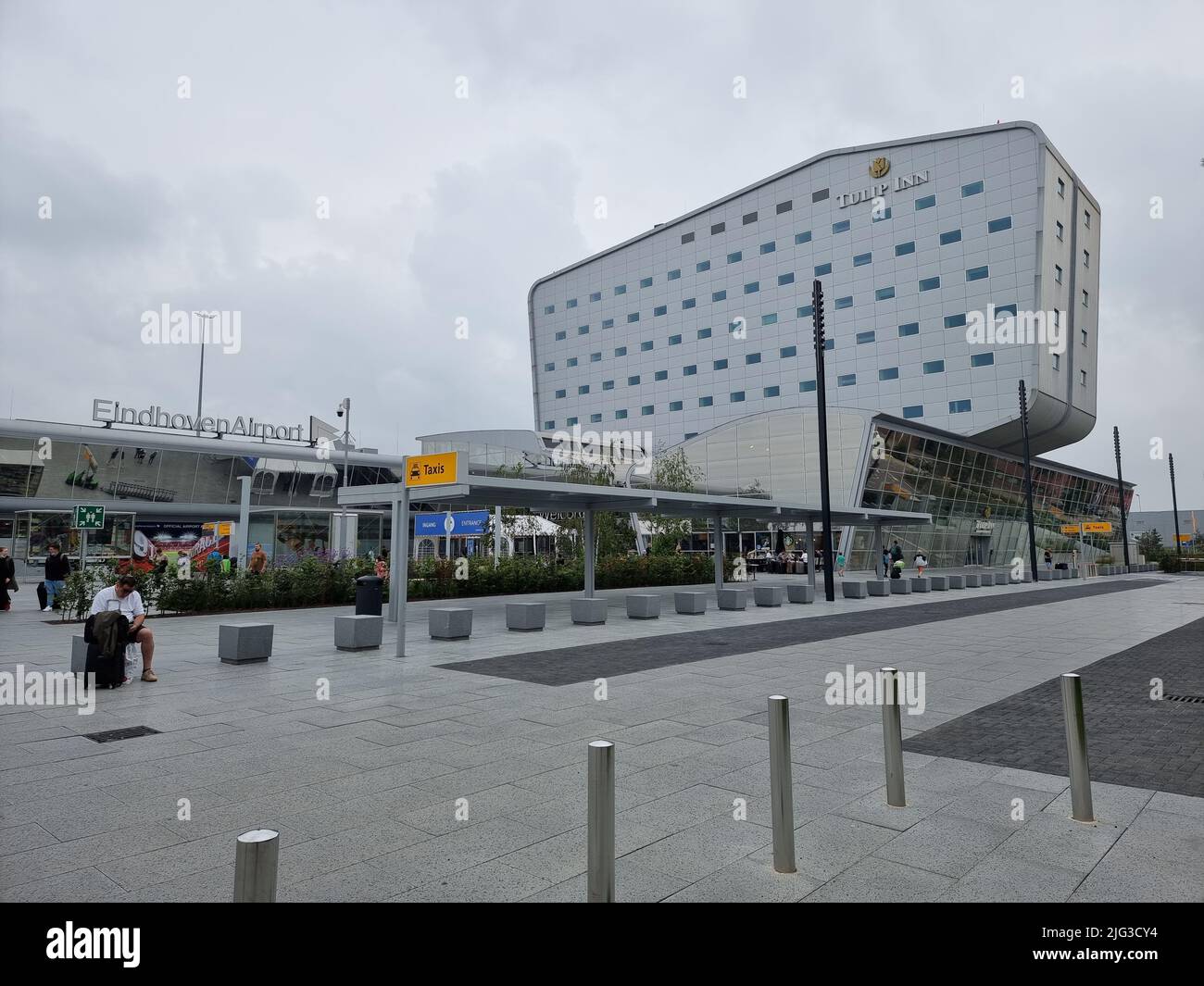 View on Eindhoven Airport, with Tulip Inn hotel above terminal; man is sitting near the taxi stand Stock Photo
