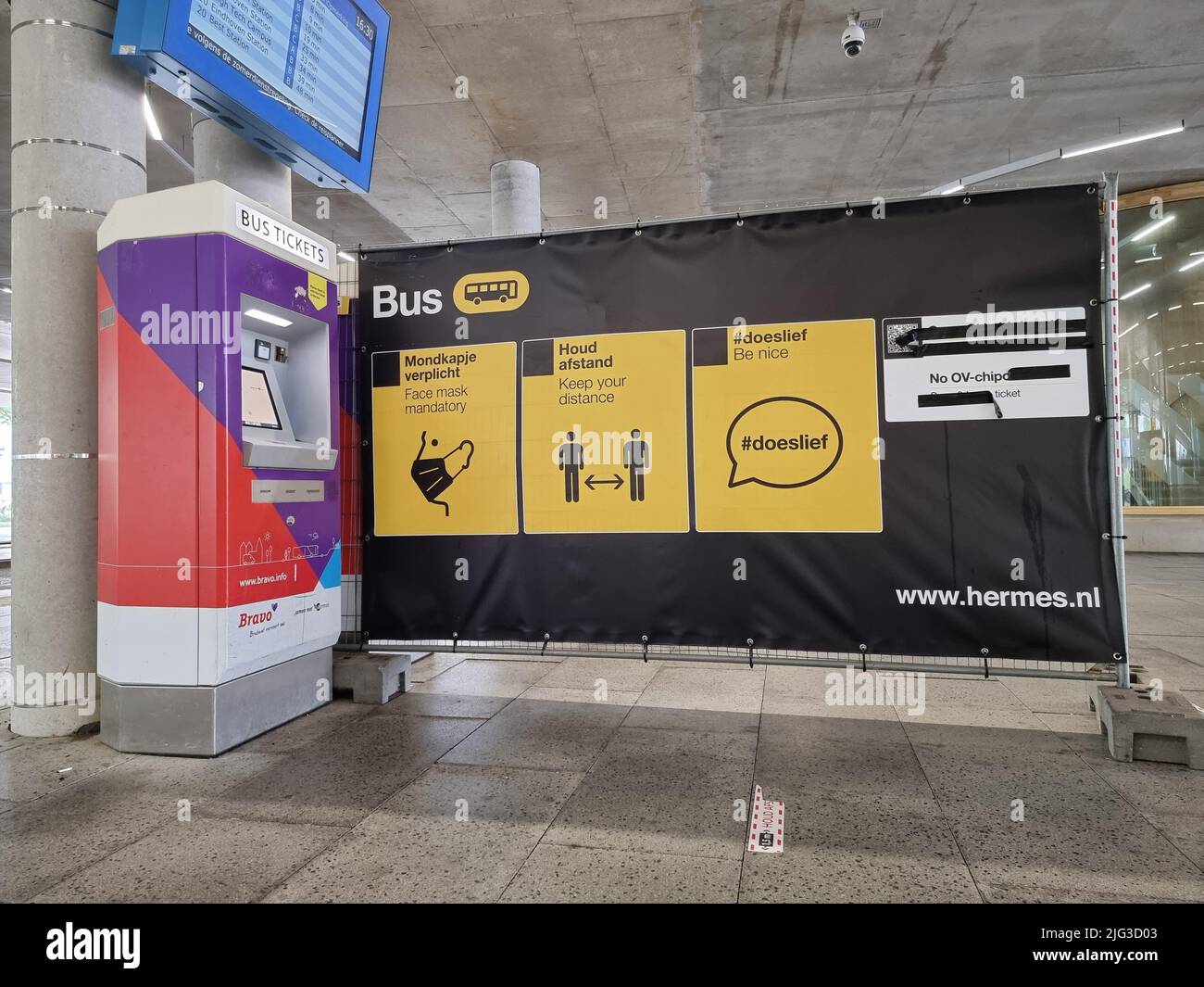 Dutch signs depicting corona measures (keep distance, face mask mandatory, etc.) at the bus station of Eindhoven Airport in the Netherlands Stock Photo