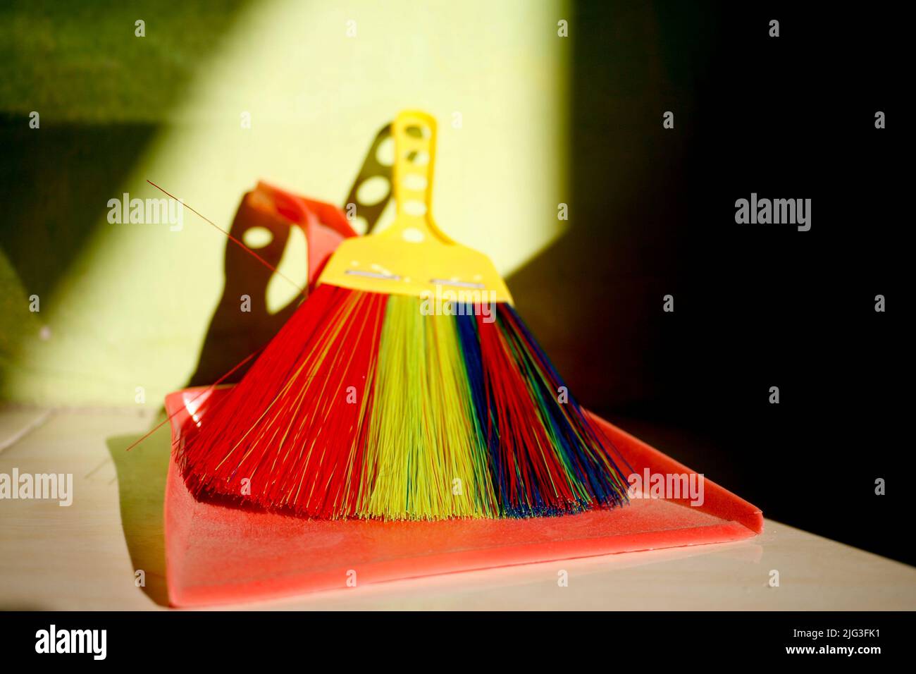Red dustpan and colourful brush Stock Photo